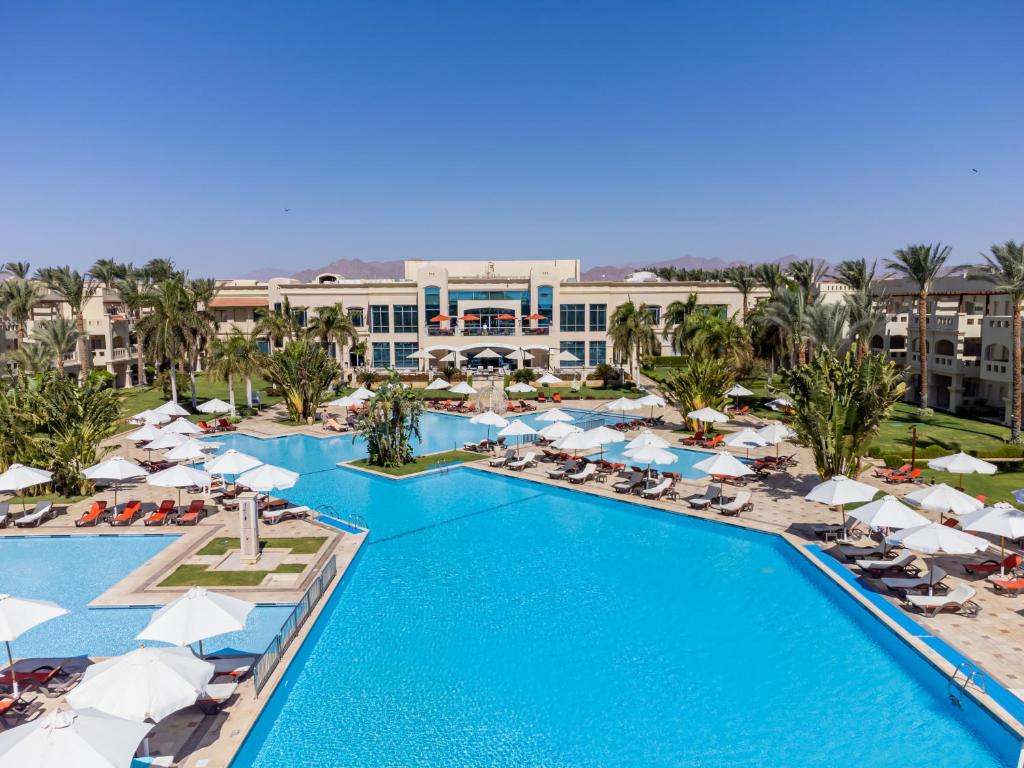 Rixos Sharm El Sheikh viesnīca ar plašu peldbaseinu un palmām