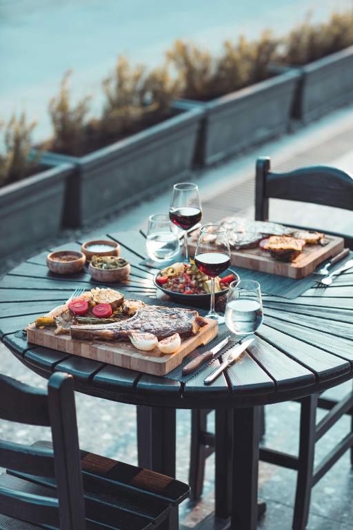 Gourmet meal at Paloma Orenda with wine and salad on a wooden table.