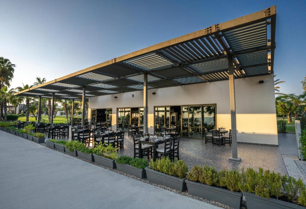 Restorāns ar terasi viesnīcā Paloma Orenda, piekrastē un zaļumiem.