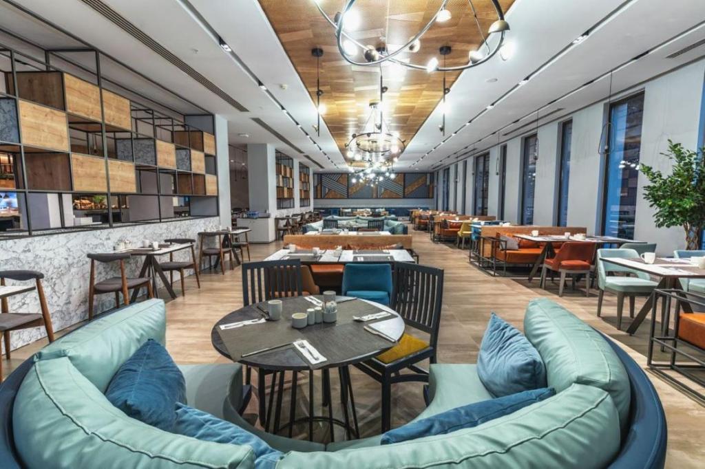 Mūsdienīgs restorāns viesnīcā Paloma Orenda ar elegantām mēbelēm un gaisotni.