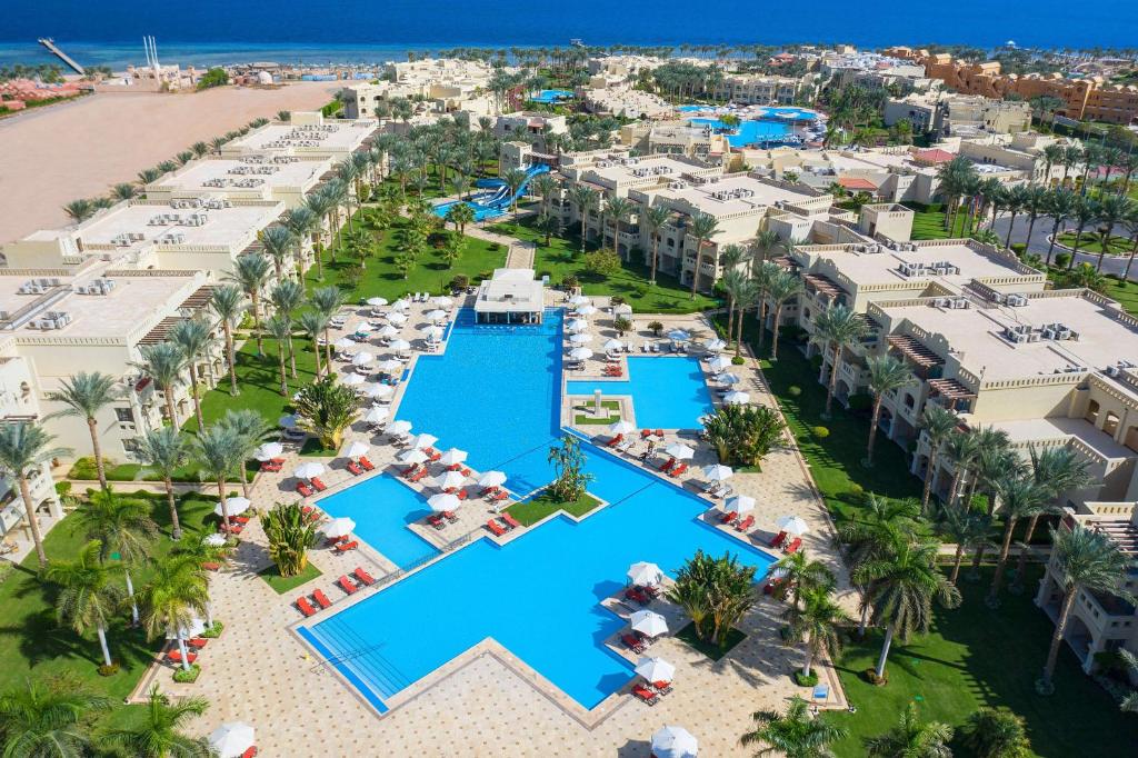 Rixos Sharm El Sheikh viesnīcas baseins ar palmām un jūru fona
