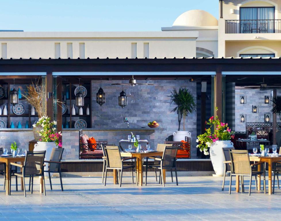 Āra restorāns Steigenberger Alcazar ar ziediem un galdiem piekrastē