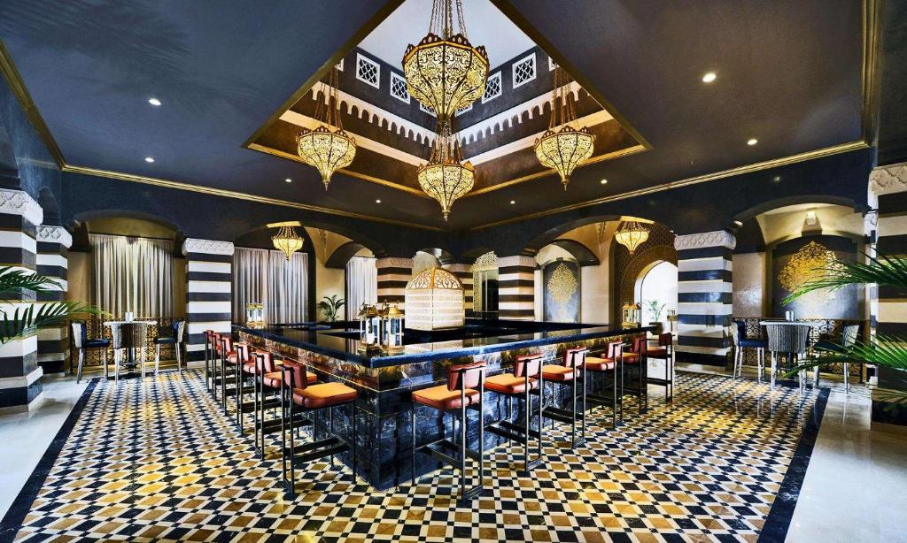 Elegants bārs Steigenberger Alcazar ar melnbaltu grīdu un greznām lampām.