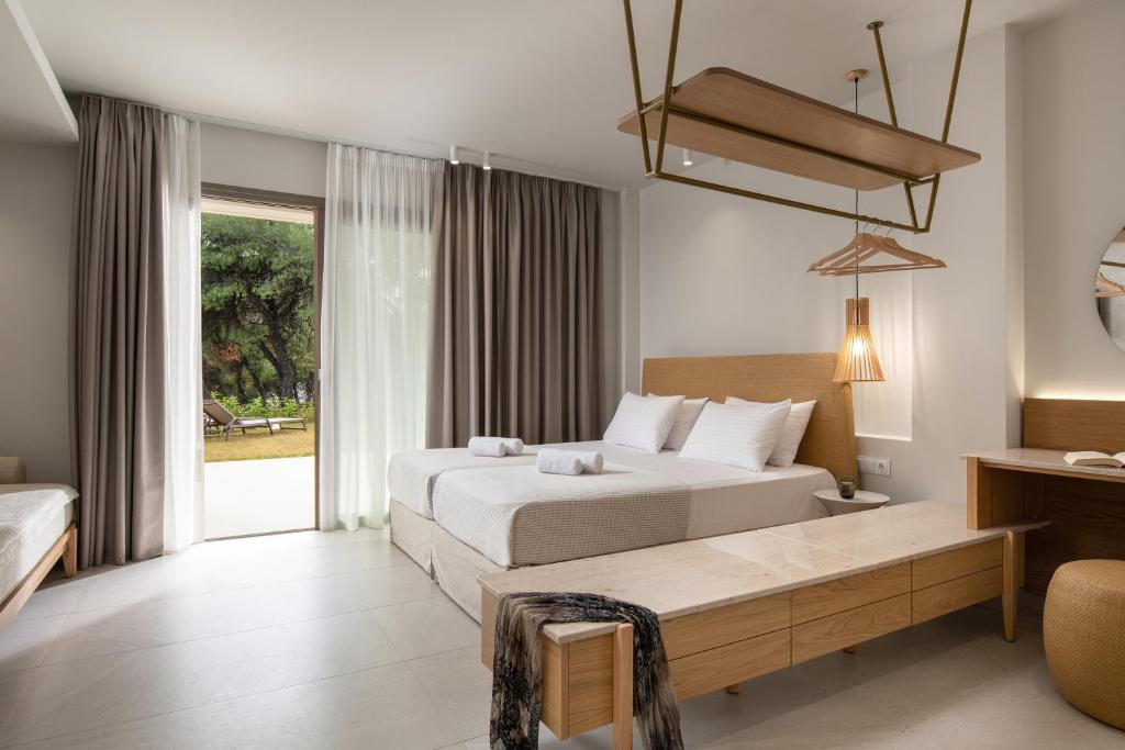 Mūsdienīgs viesnīcas numurs ar divām gultām, koka mēbelēm un lieliem logiem, caur kuriem redzams dārzs. Interjers ir gaišs un elegants, rada relaksējošu atmosfēru.