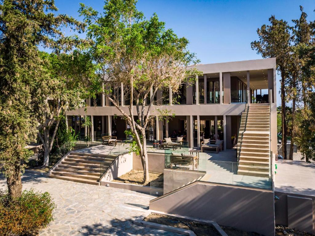 Modernā ēka pie White Olive Premium Lindos viesnīcas, ieskauta zaļumā.