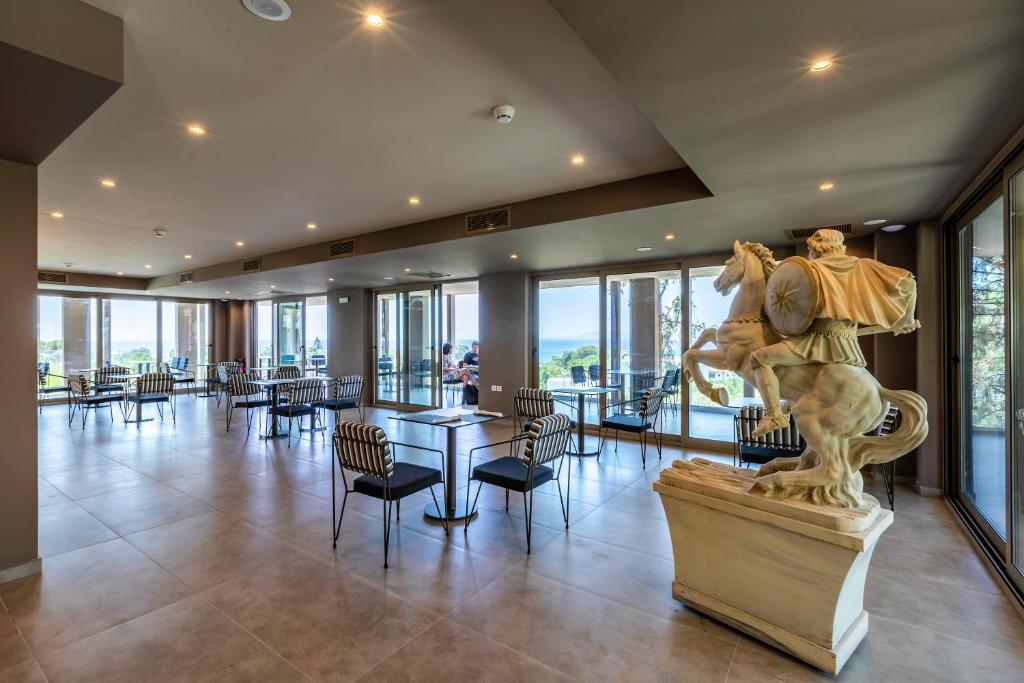 Elegantā restorāna interjers viesnīcā White Olive Premium Lindos ar skatu uz piekrasti.