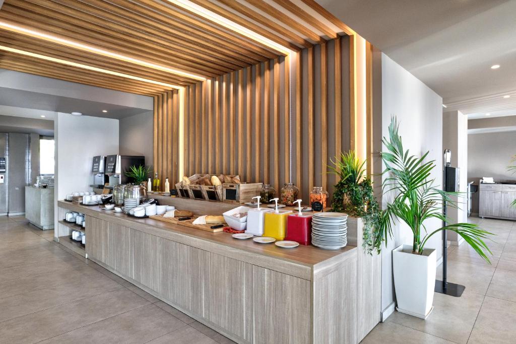 Brokastu bufete White Olive Premium Lindos ar svaigiem produktiem un dzērieniem.