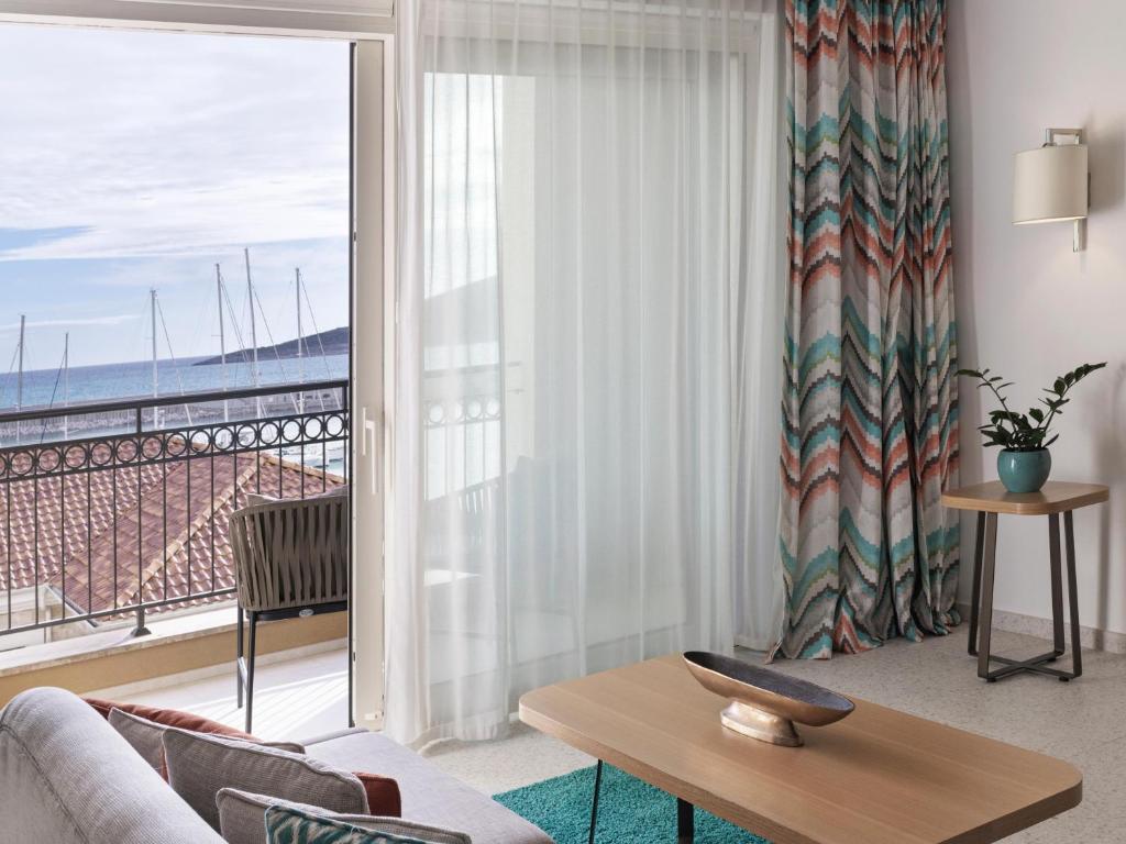 Mūsdienīgs viesnīcas numurs ar balkonu, no kura paveras skats uz jūru un jahtu piestātni. Interjerā ir stilīgas krāsainas aizkaru drānas un koka mēbeles, radot mājīgu atmosfēru.