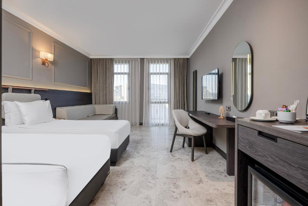 Moderns numurs Adora Hotel & Resort ar divguļamo gultu un atpūtas zonu.