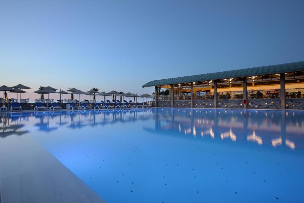 Peldbaseins Arina Beach Resort piekrastē, apgaismojums un saulessargi.