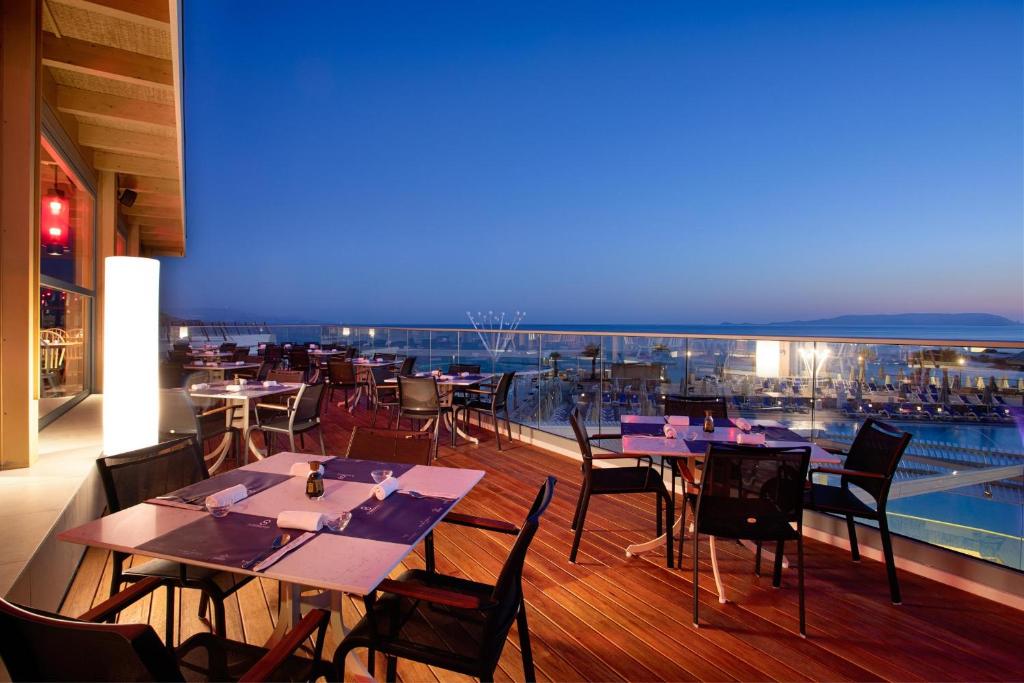 Restorāns ar skatu uz jūru pie Arina Beach Resort saulrieta laikā.