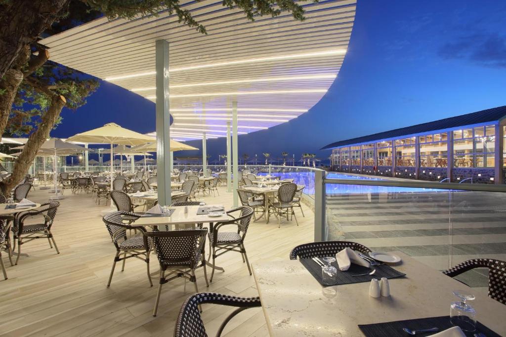 Elegantā terase Arina Beach Resort piekrastē ar ēdināšanas zonu naktī
