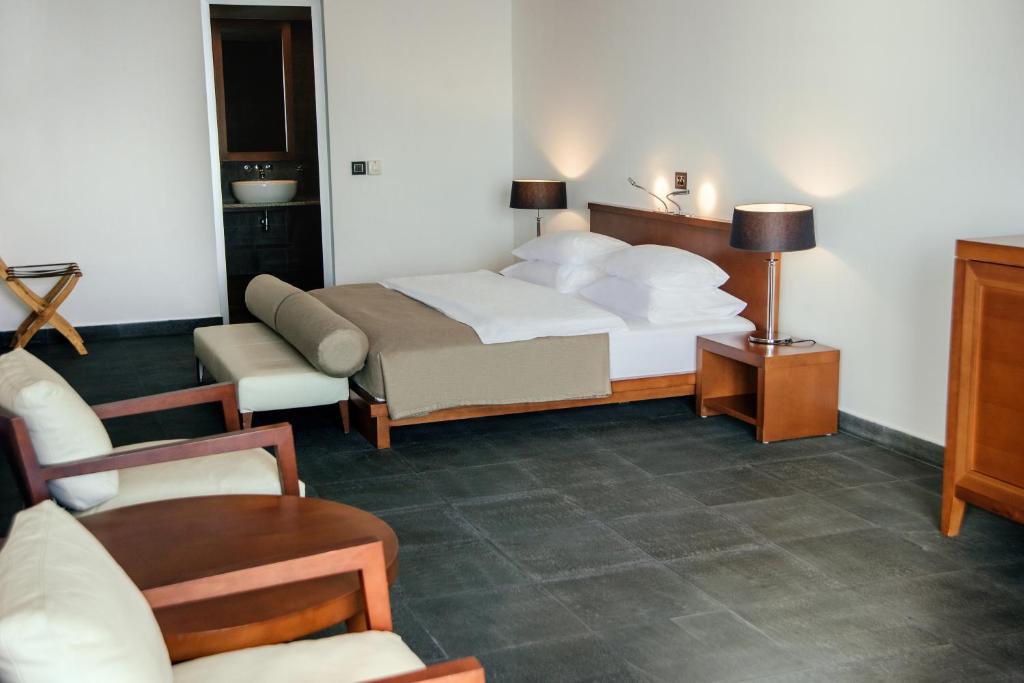 Mūsdienīgs viesnīcas numurs ar divguļamo gultu, ērtām krēsliem un galdiņu, kā arī modernām apgaismojuma ierīcēm. Numurs ir gaišs un plašs, radot komfortablu atmosfēru.