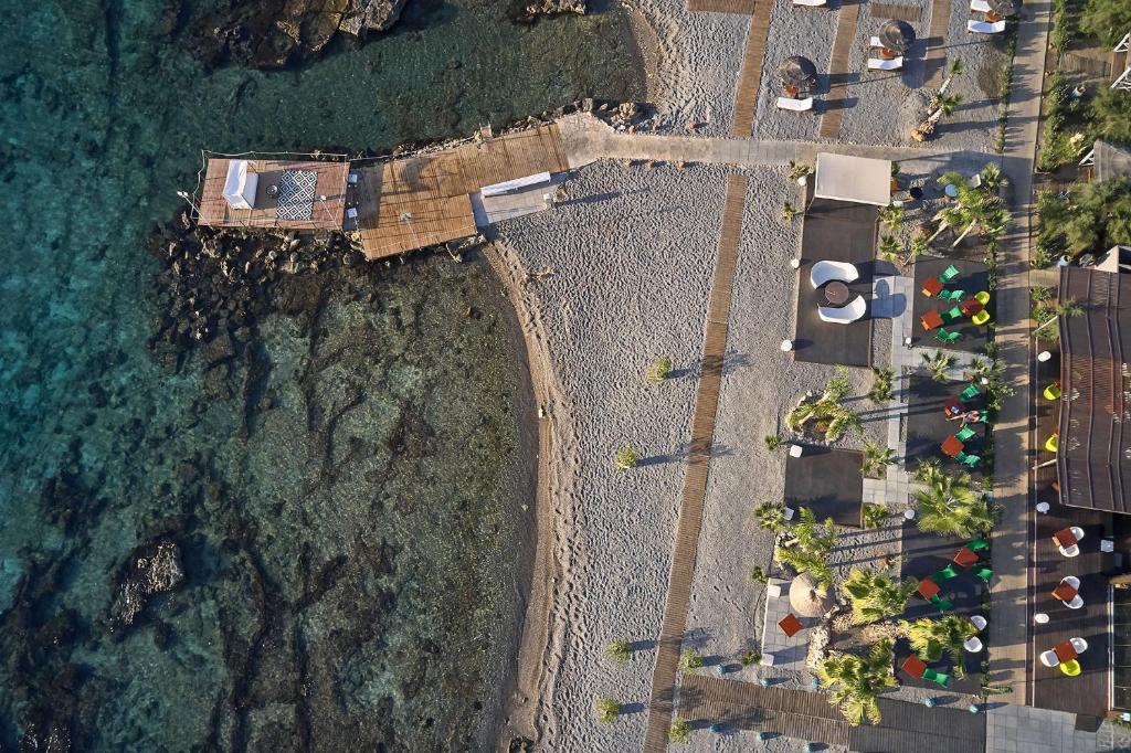 Aerial view of the beach area at Aquagrand Exclusive Deluxe Resort with lounge chairs.