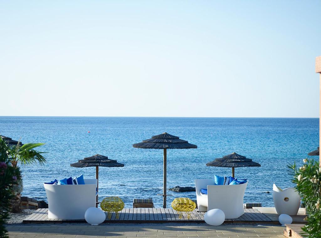 Skats uz jūru no Aquagrand Exclusive Deluxe Resort ar baltiem krēsliem un saulessargiem.