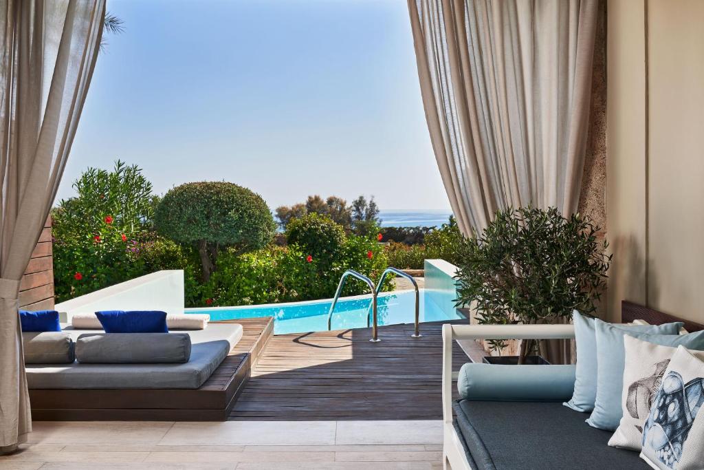 AquaGrand Exclusive Deluxe Resort numura balkons ar privātu baseinu un skatu uz dārzu.