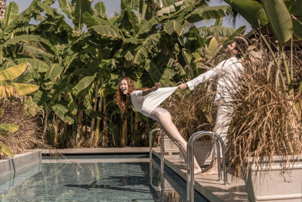 Priecīgi viesi izbauda atpūtu pie Balmy Beach Resort Kemer baseina.