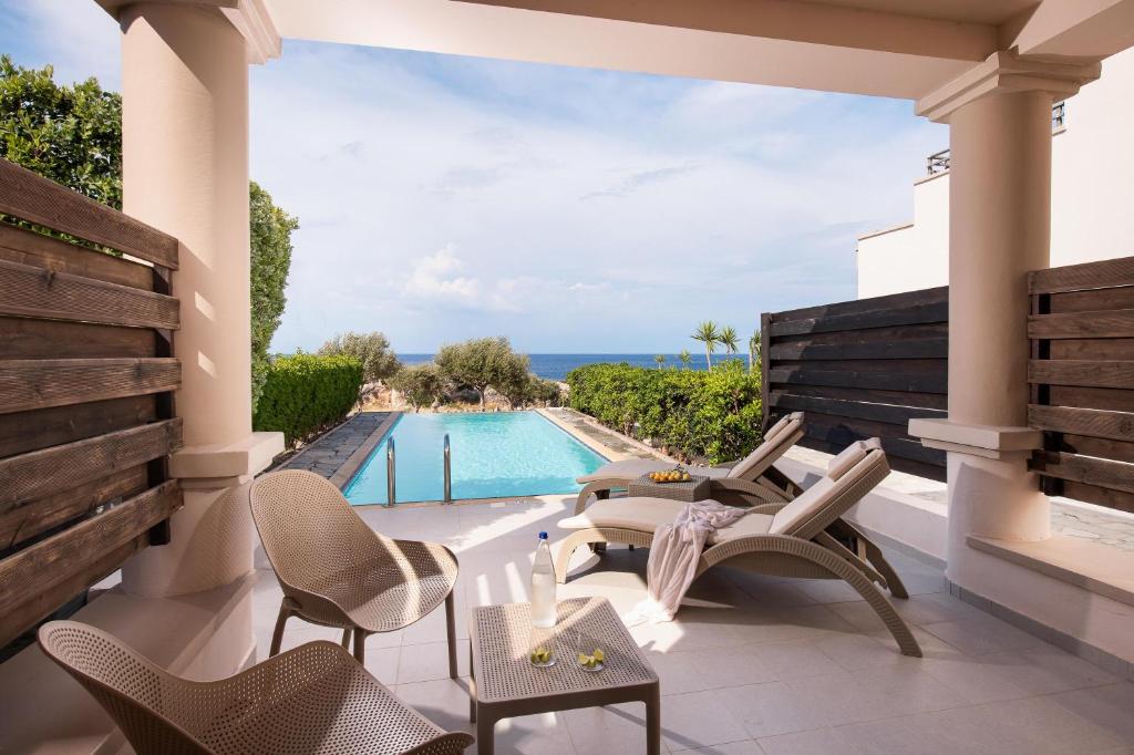 Kresten Royal Euphoria Resort privātā terase ar skatu uz baseinu un jūru.