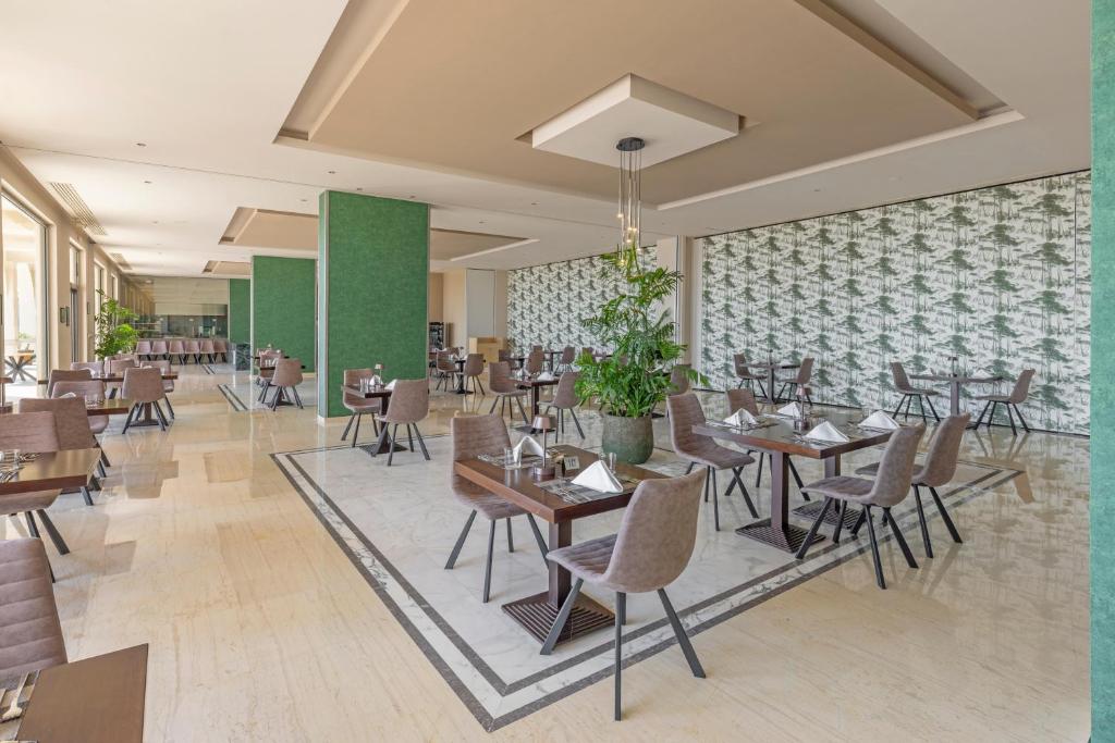 Moderns restorāns Kresten Royal Euphoria Resort ar elegantiem galdiem un krēsliem.