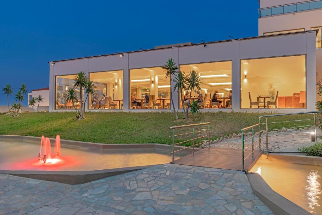 Kresten Royal Euphoria Resort ēdamzāle ar skatu uz dārzu un strūklaku piekrastē.