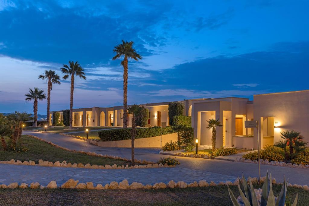 Kresten Royal Euphoria Resort piekrastē ar palmām un apgaismotu takti