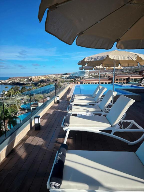Saulainā terase ar sauļošanās krēsliem un saules nūjām, skats uz jūru un viesnīcām. Ideāla vieta atpūtai un relaksācijai.