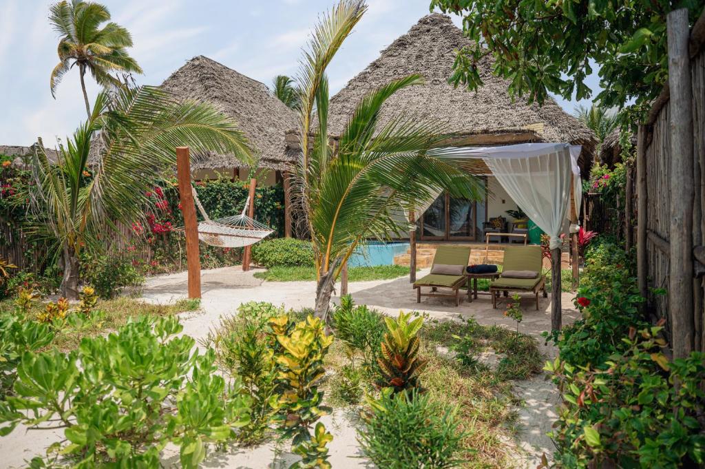 Zanzibar Queen bungalo piekrastē ar dārzu un šūpuļtīklu.