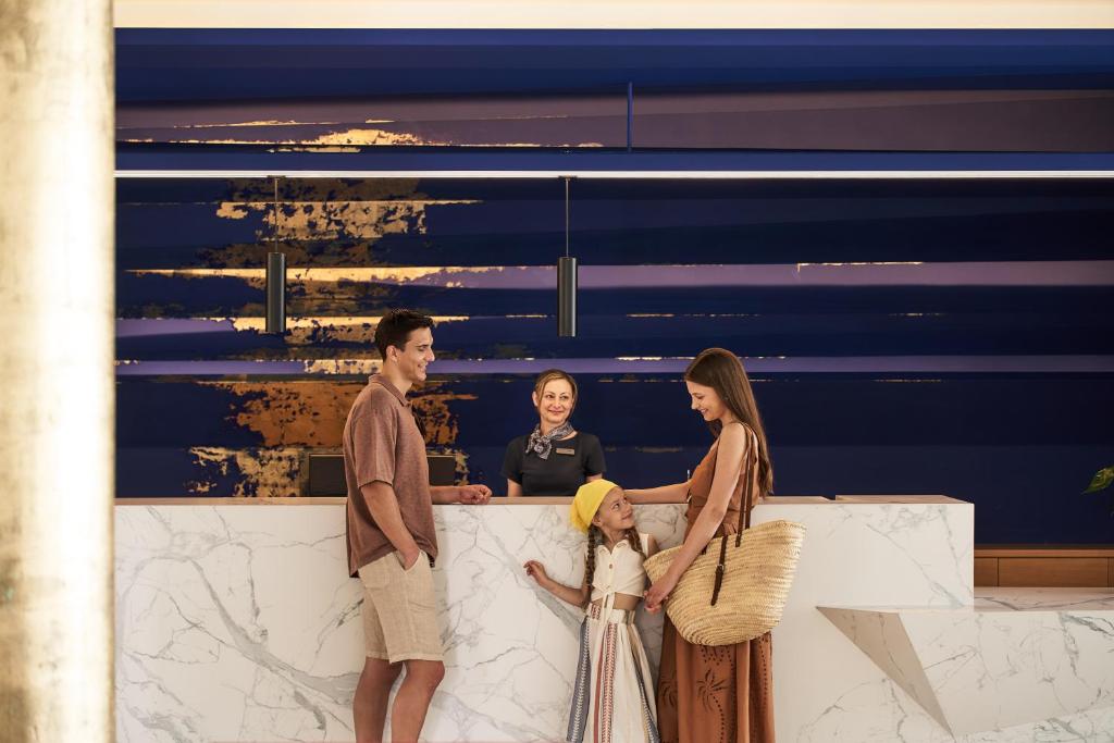 Arina Beach Resort reģistratūra, laimīga ģimene un laipns personāls.