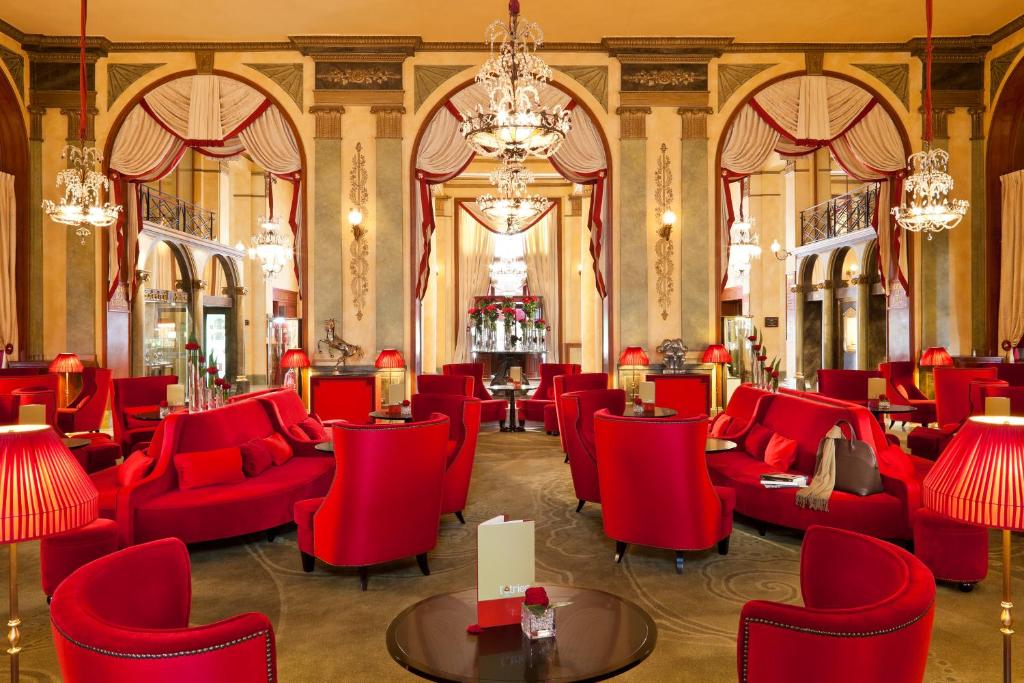 Eleganta viesnīcas Hôtel Barrière Le Royal Deauville atpūtas zona ar sarkaniem dīvāniem.
