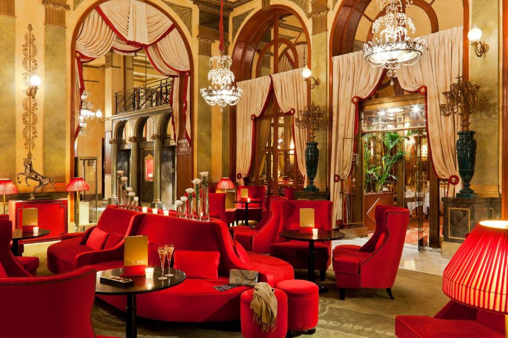 Elegants salons viesnīcā Hôtel Barrière Le Royal Deauville ar sarkaniem krēsliem