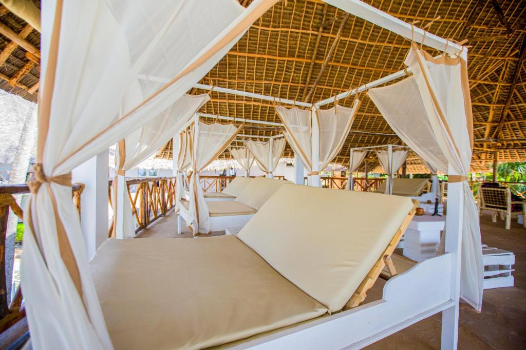 Atpūtas zona AHG Dream's Bay Beach ar ērtām gultām un aizkariem.