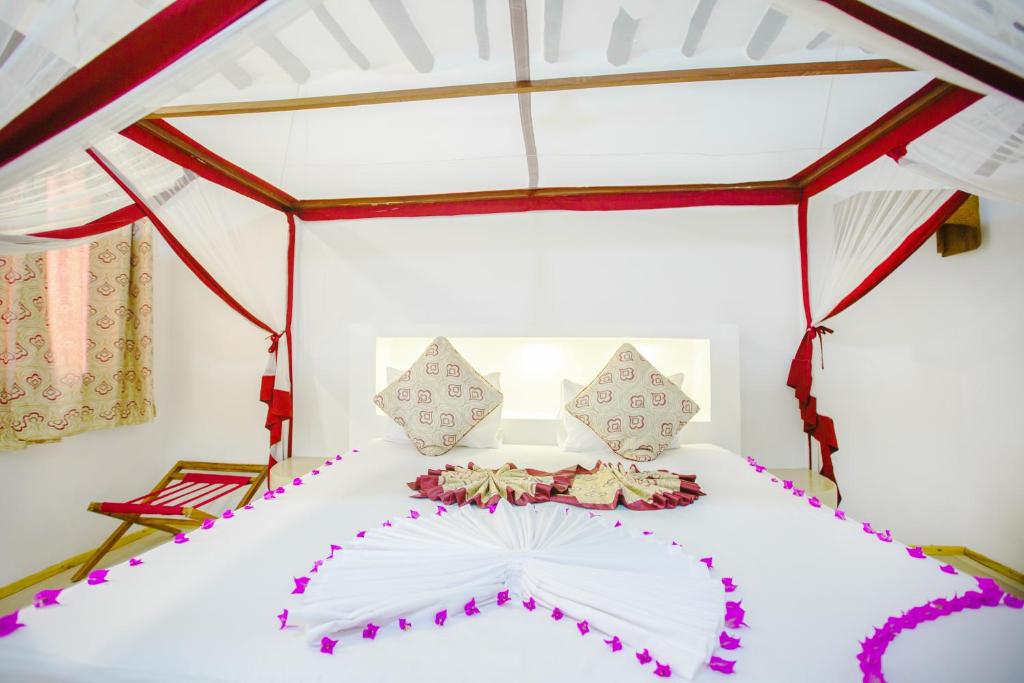 Romantisks numurs AHG Dream's Bay Beach viesnīcā ar dekorētu gultu.