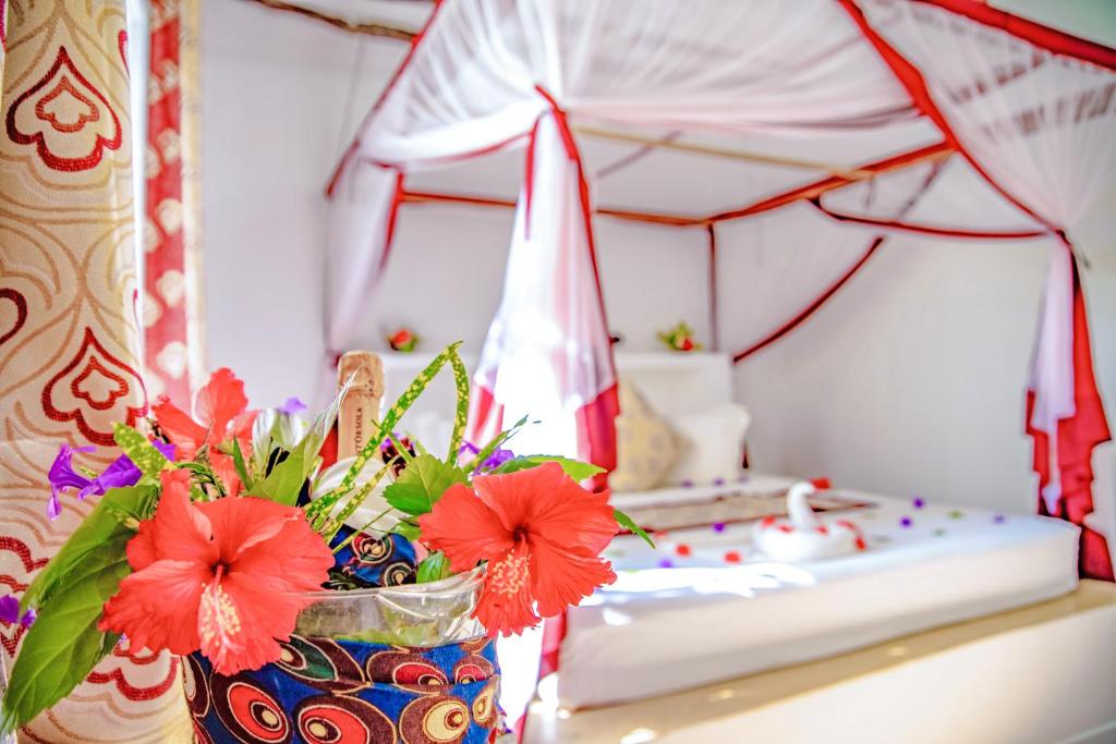 Romantisks numurs AHG Dream's Bay Beach viesnīcā ar ziedu un gultas dekorācijām.