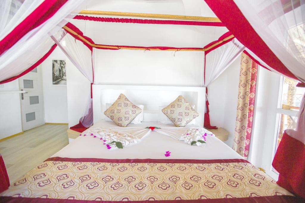 Romantisks numurs AHG Dream's Bay Beach ar baldahīnu un dekoratīviem ziediem.