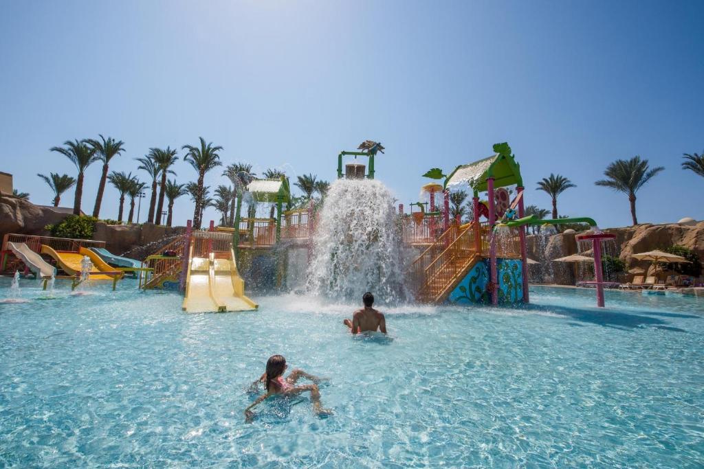 Bērni izklaidējas ūdens parkā pie Reef Oasis Beach Resort, ar slidkalniņiem un ūdens kritumu.