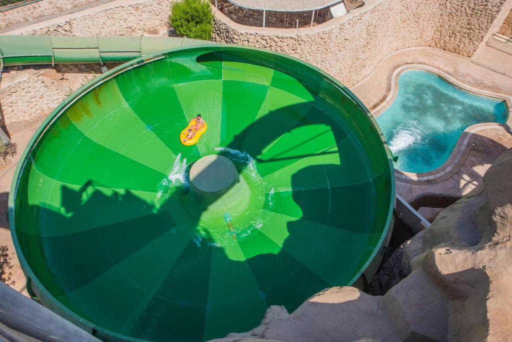 Viesnīcas Reef Oasis Beach Resort zaļais ūdens slidkalniņš ar apmeklētāju.