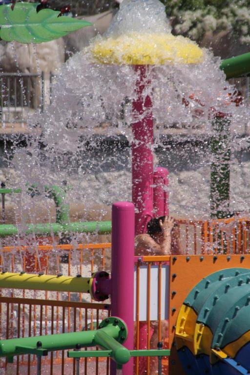 Ūdens atrakciju zona Reef Oasis Beach Resort ar strūklaku un bērniem.