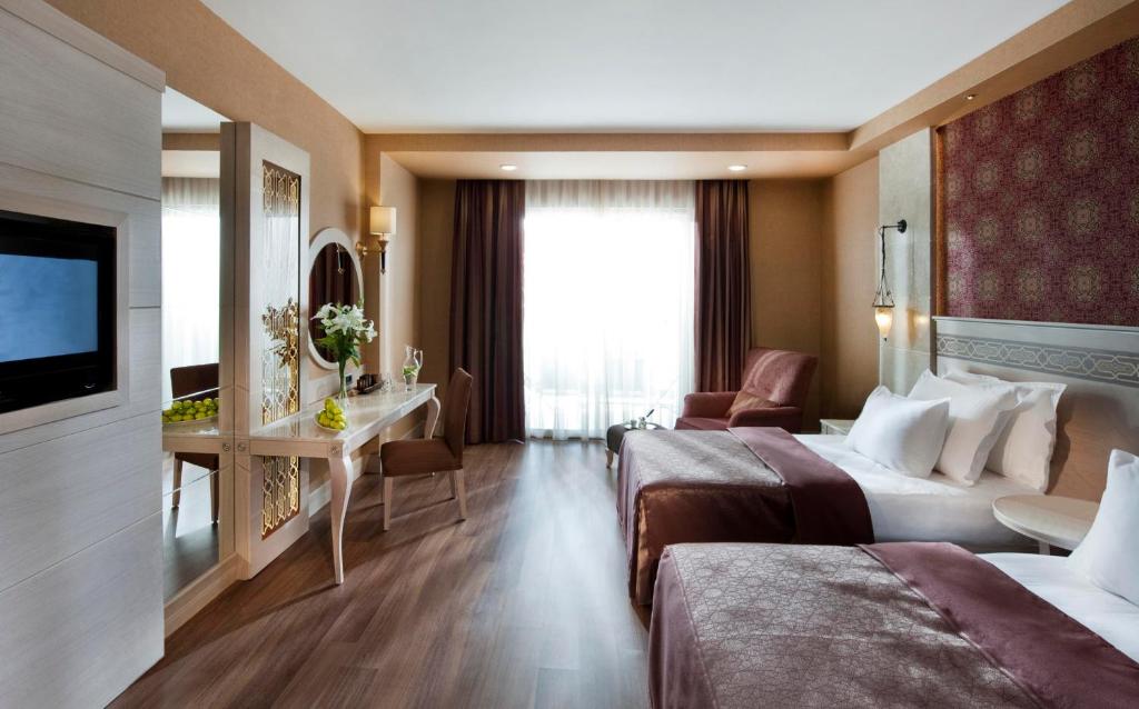 Mūsdienīgs viesnīcu numurs ar divām gultām, elegantu interjeru un plašiem logiem, kas nodrošina dabisko apgaismojumu. Istabā ir arī rakstāmgalds un komfortabla atpūtas zona.