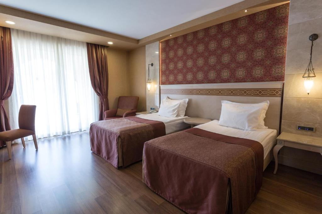Mūsdienīga hotel numura iekārtojums ar divām atsevišķām gultām, elegantiem aizkariem un siltu koka grīdu. Gaismas avoti un moderni mēbeļu elementi rada patīkamu atmosfēru.