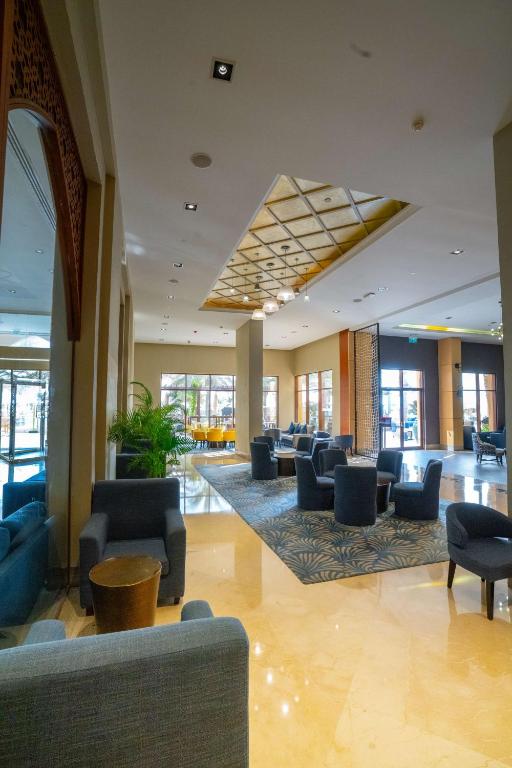 Mūsdienīgs viesnīcas vestibils ar elegantu apgaismojumu, stilīgu mēbelēšanu un plašām atpūtas zonām. Viegli pieejama vieta, ideāli piemērota viesu atpūtai un socializācijai.