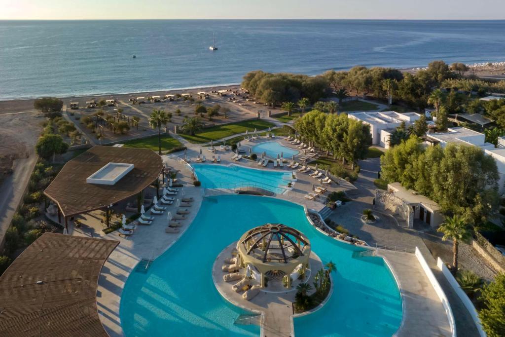 Lindian Village Beach Resort Rhodes, Curio Collection by Hilton baseins piekrastē ar palmām