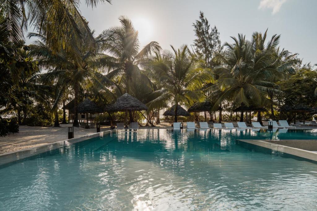 Mwezi Boutique Resort baseins ar palmām piekrastē