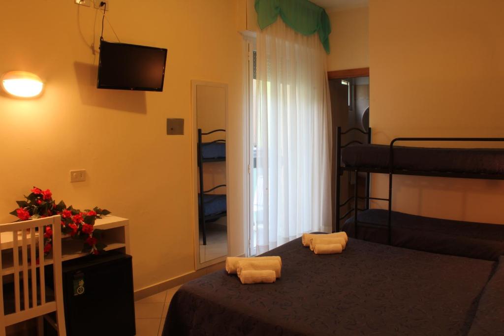 Mūsdienīga viesnīcas istaba ar divguļamo gultu, bunkuru gultām un televizoru. Istabā ir rakstāmgalds, ledusskapis un dabīgā apgaismojuma avots no loga.