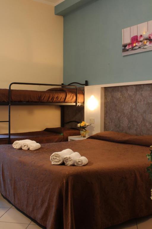 Mūsdienīga viesnīcas numura iekārtojums ar divām gultām un bunkura gultu, kā arī dekora elementiem un ziedu kompozīciju. Numurā ir gultas veļa un dvieļi.