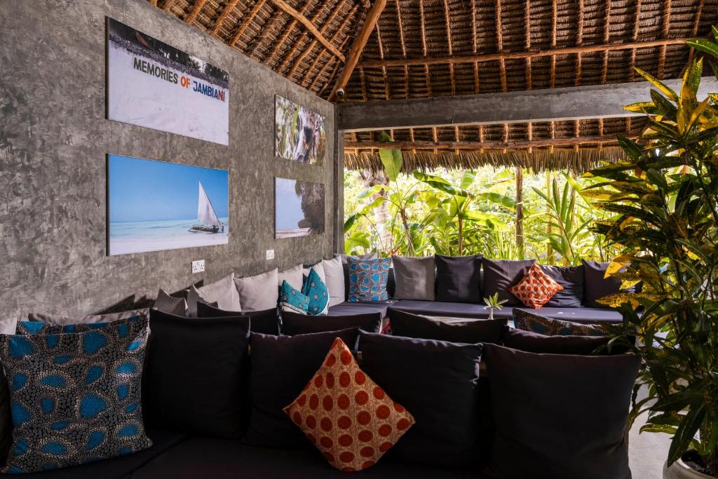 Atpūtas zona Fun Beach Zanzibar ar spilveniem un mākslas darbiem.