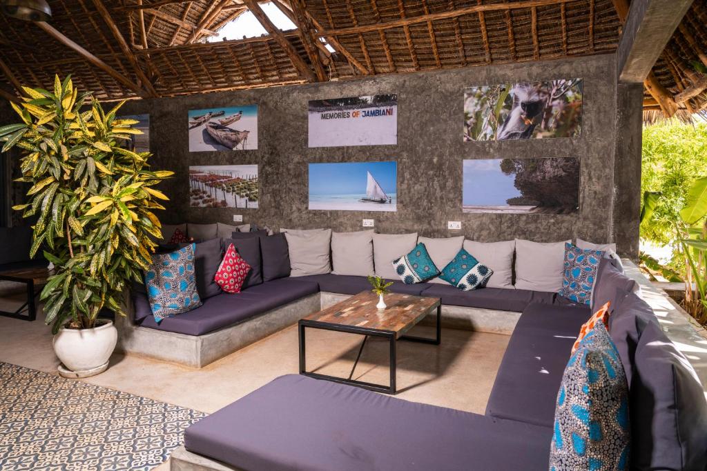 Atpūtas zona viesnīcā Fun Beach Zanzibar ar spilgtām spilveniem un mākslas darbiem.
