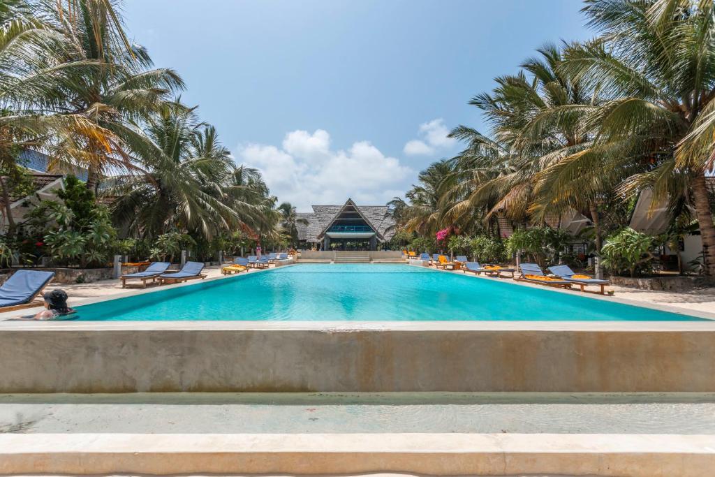 Fun Beach Zanzibar baseins ar palmām un sauļošanās krēsliem.