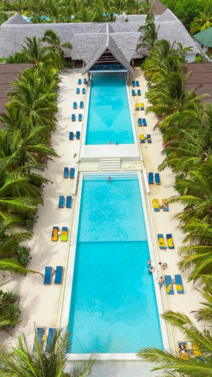 Fun Beach Zanzibar baseins ar pludmales krēsliem un palmām.