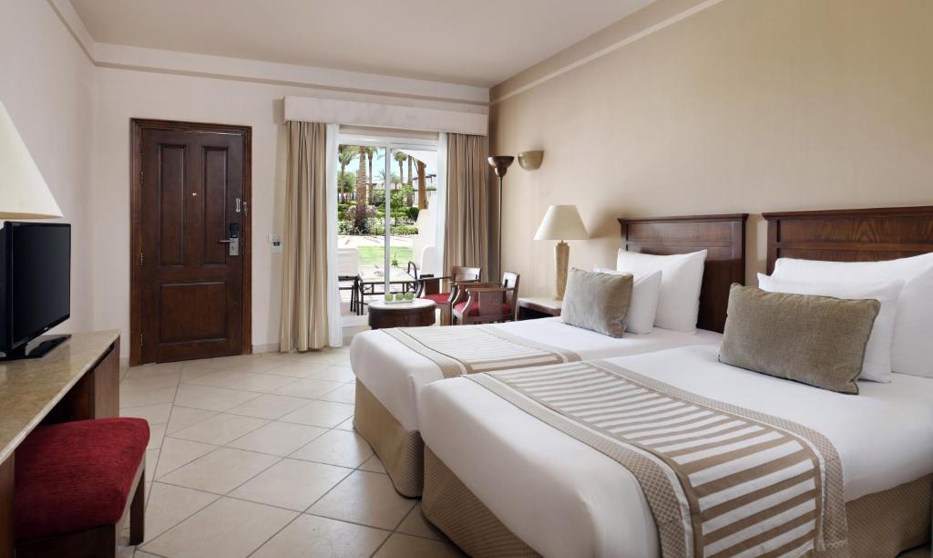 Numurs ar divām gultām pie viesnīcas Jaz Dahabeya, skats uz dārzu.