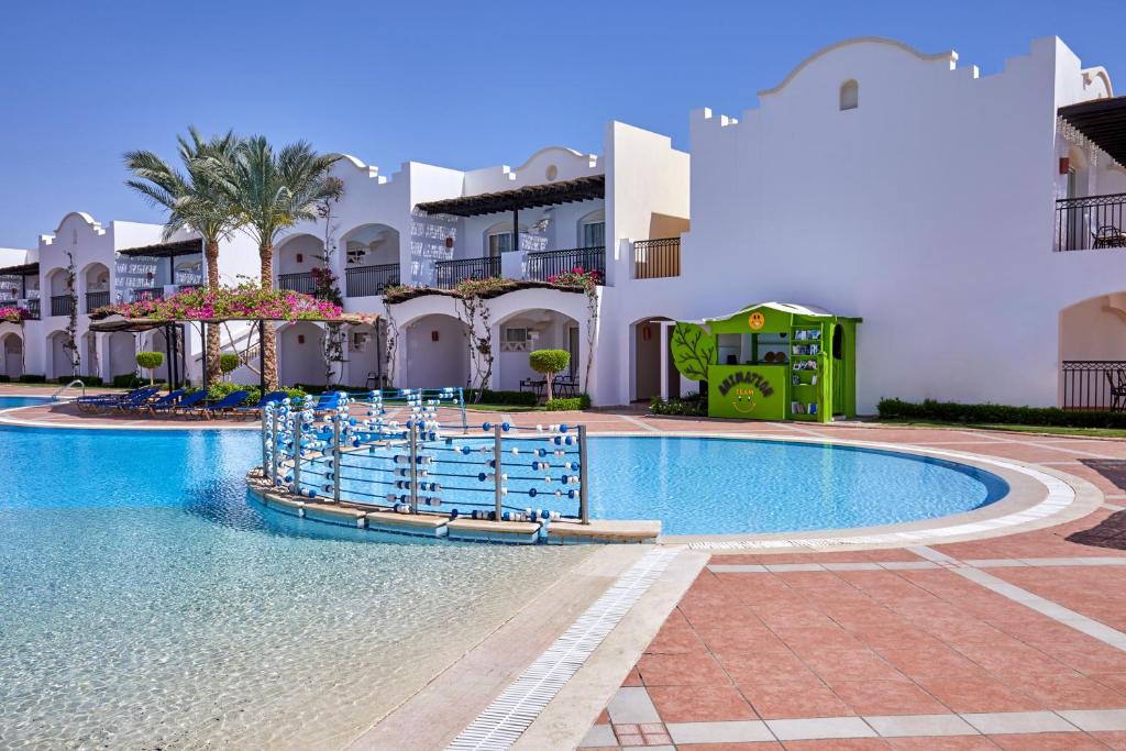 Jaz Dahabeya baseins ar ziediem un palmu kokiem apkārt.